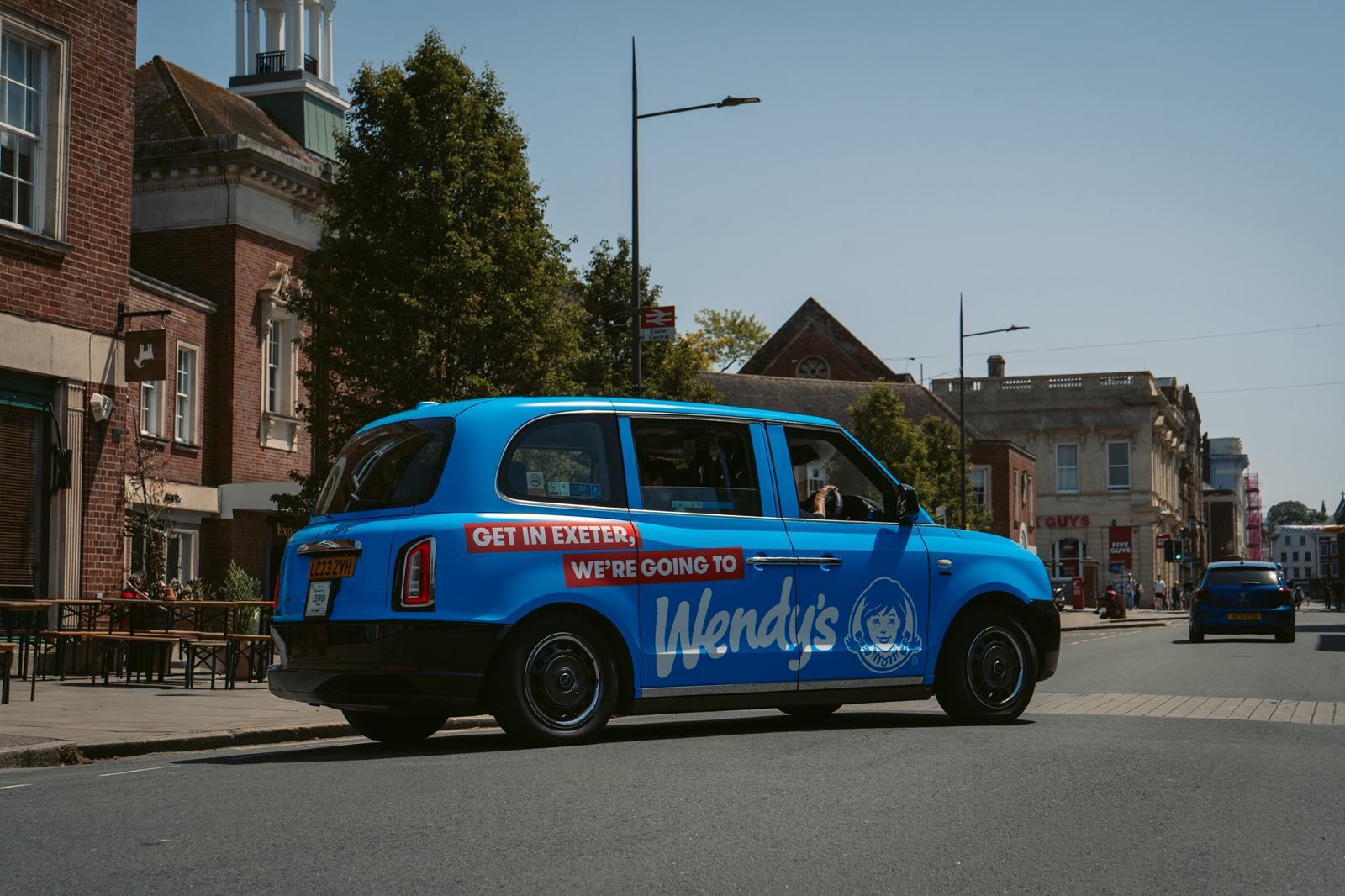 Branded Wendy's taxi campaign driving through Exeter city centre